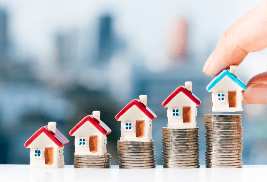 An image of little house figurines on coins in an ascending order, highlighting whether a person should invest in properties. 